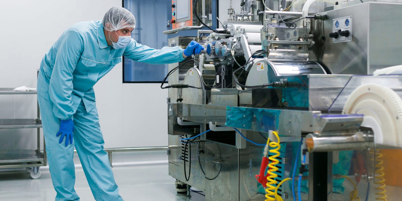 bended-caucasian-scientist-blue-lab-suit-trying-fix-manufacture-machine-with-shafts (1)